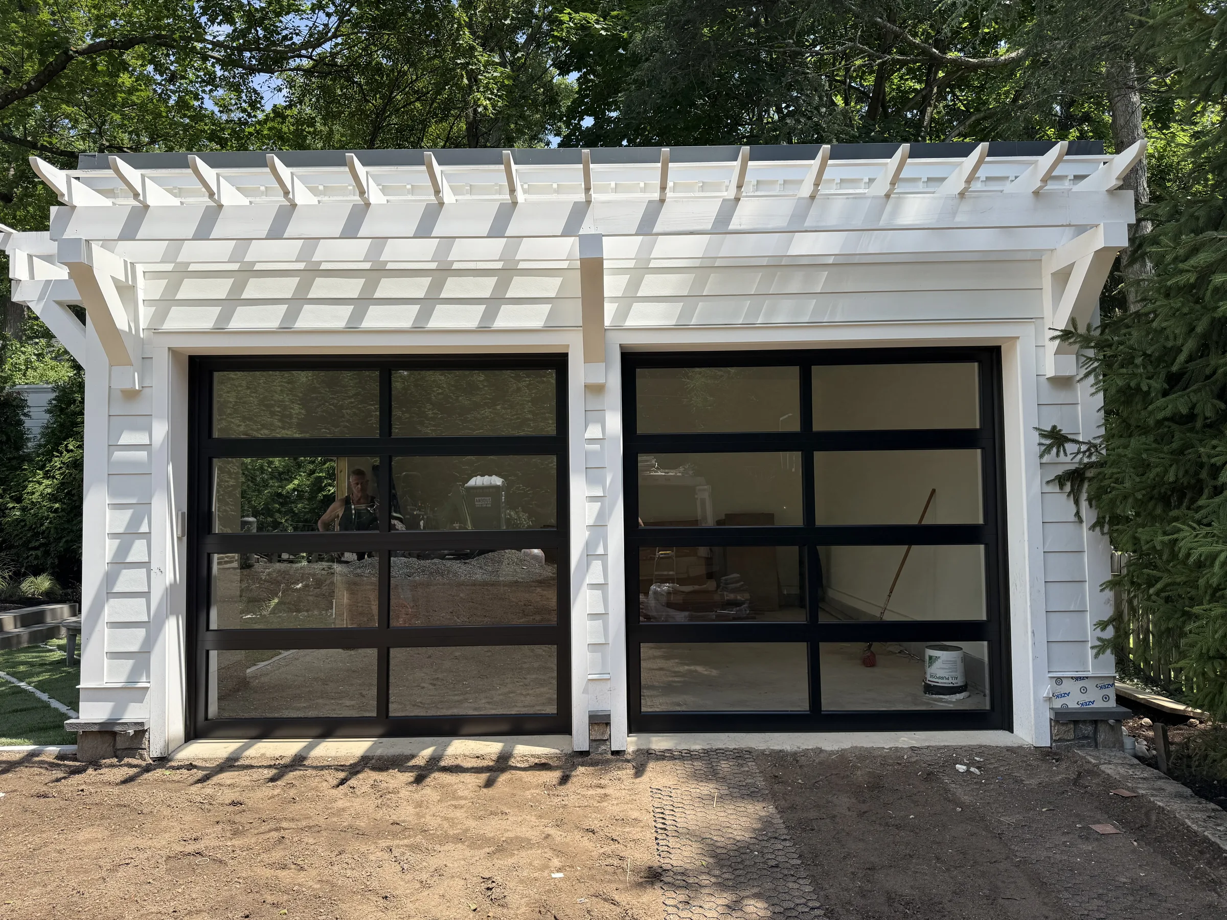 Pair of black full-view glass garage doors with black frames on a residential garage.